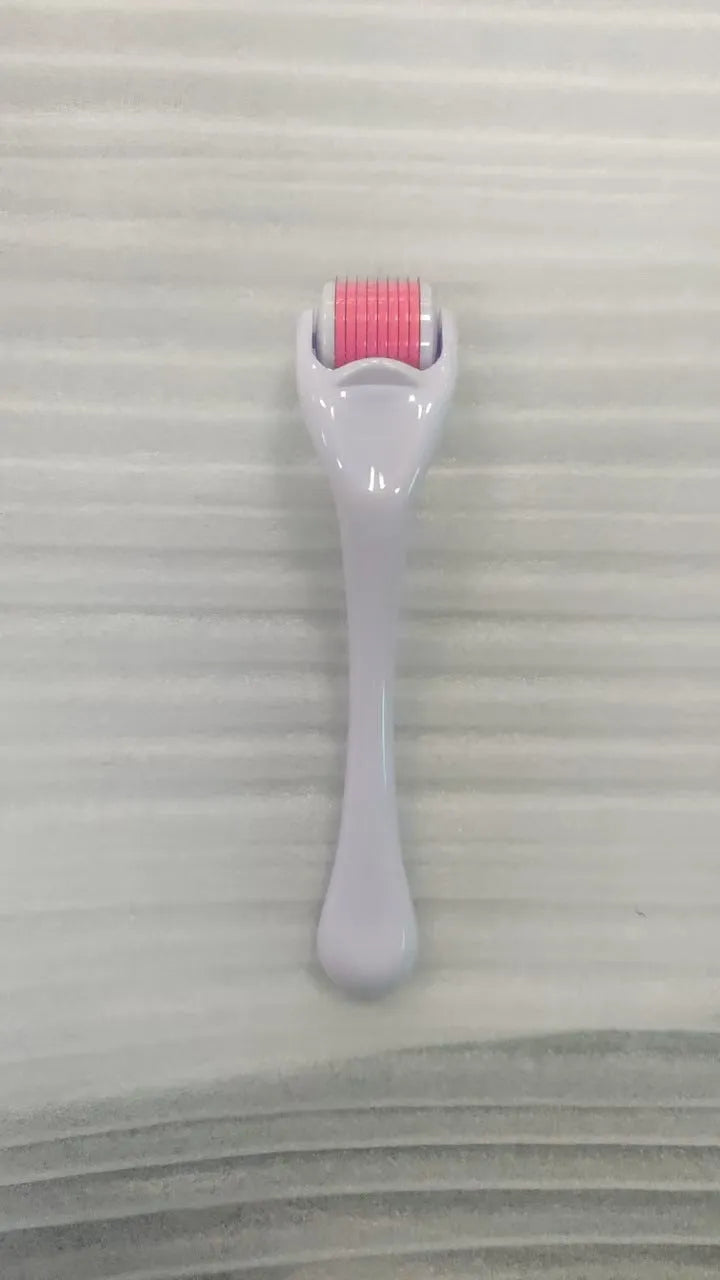 540 micro needle roller tool with black handle and coloured wheel on a white background.
