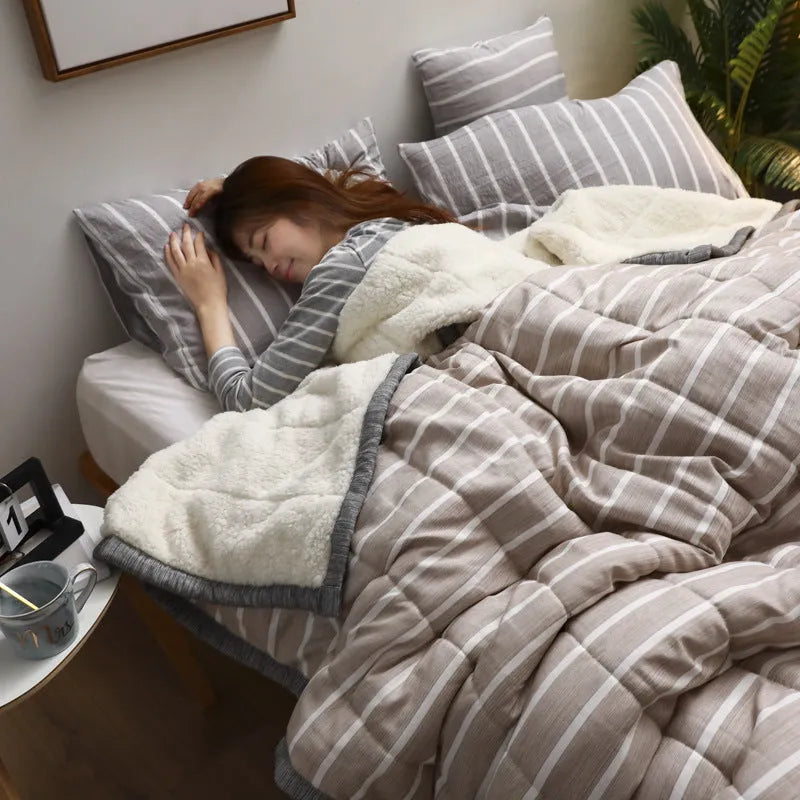 Thick coral fleece winter blanket in a solid colour, shown on a bed, dimensions 150cm by 200cm.