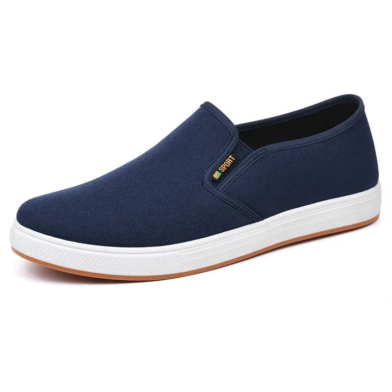 Men's low-top black canvas slip-on shoes with round toe and shallow mouth on a composite sole.