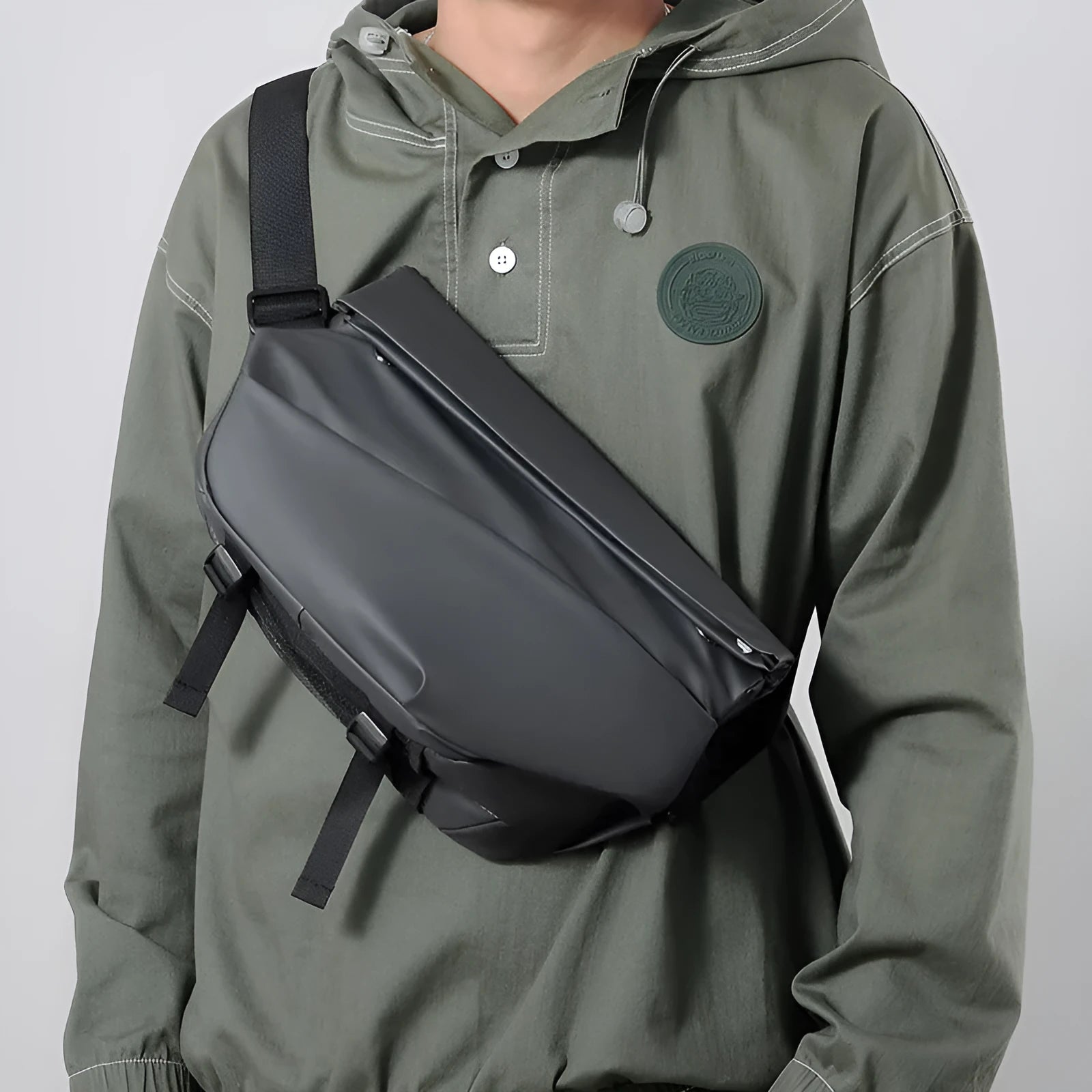 Grey PU leather men's crossbody sling backpack showing front zipper and shoulder strap.