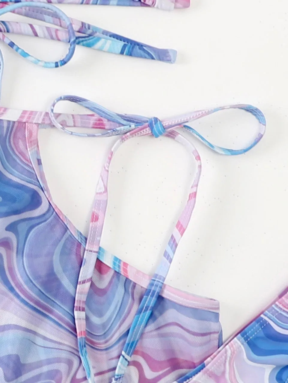 Lavender 3-piece women's bikini set with sheer beach skirt on display