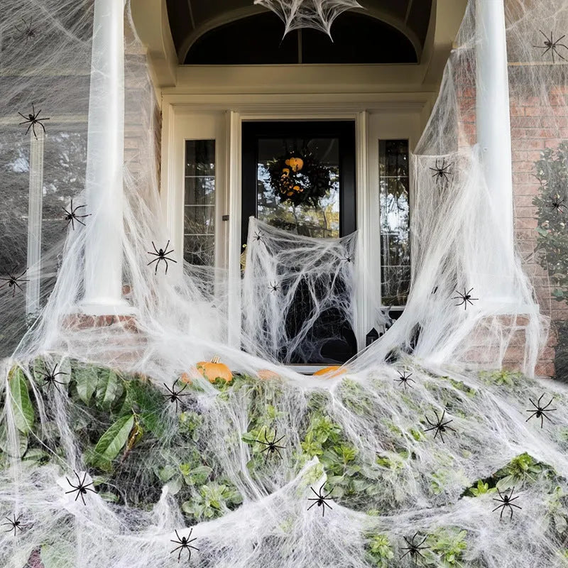 Halloween cotton spider web decoration pack with white plastic spiders draped over a branch