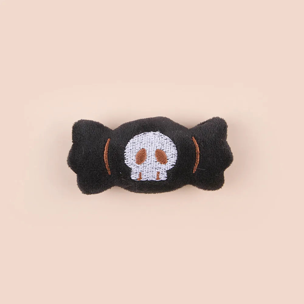 Small cat teaser wand toy with plush candy and skull attachments on string