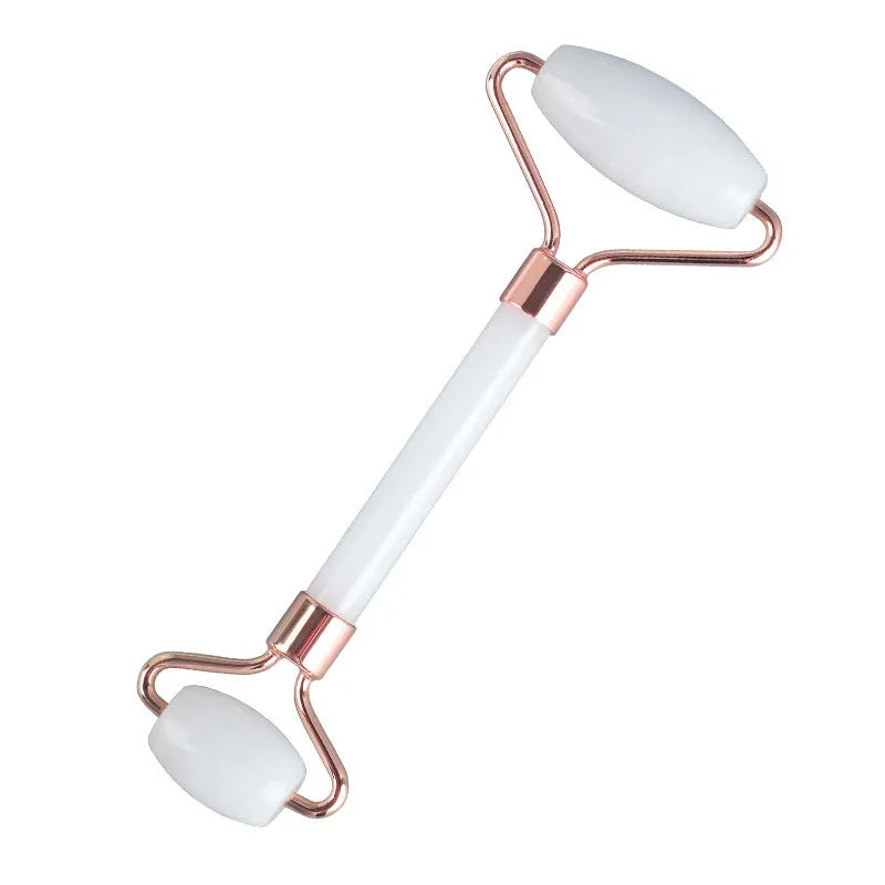 White jade facial roller and Gua Sha scraping board set on a neutral background.