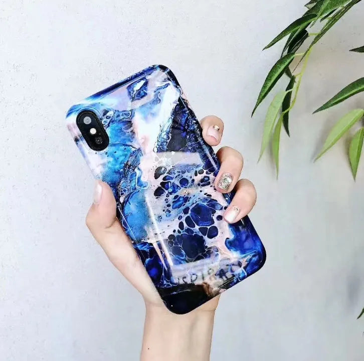 Colourful stone pattern soft protective case for iPhone X, 8, 7, 6, and 6s Plus models on a table.
