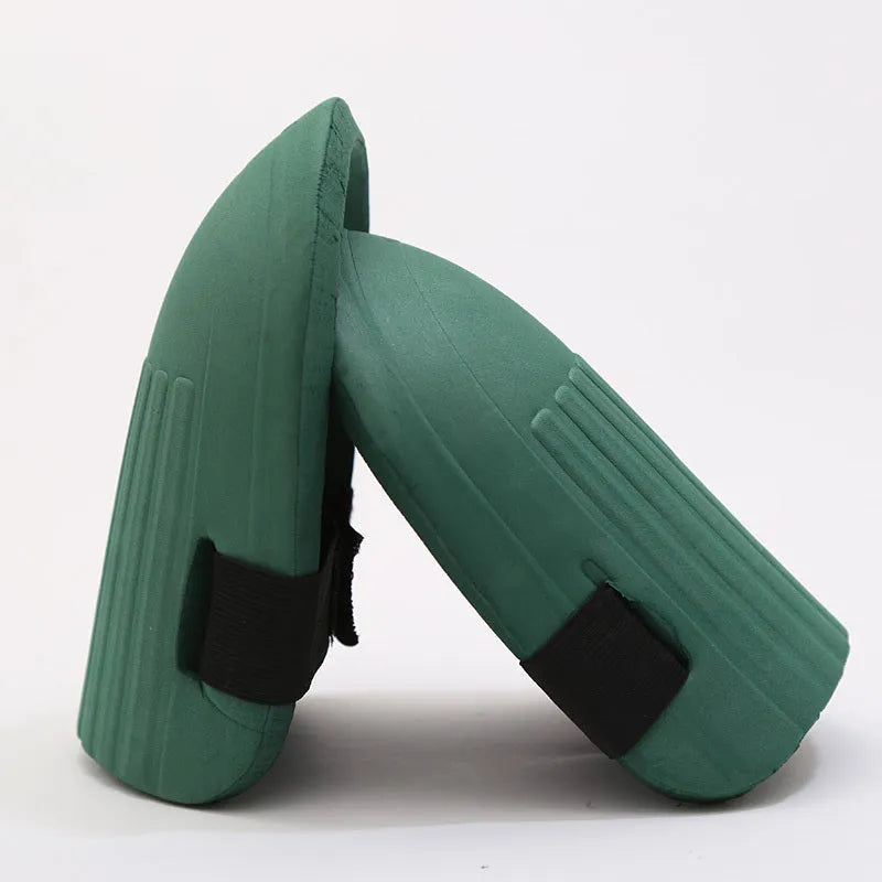 A pair of rectangular EVA foam knee pads in army green colour on a garden soil background.