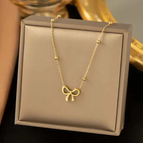 Gold bow necklace on adjustable cross chain for women