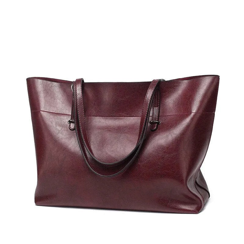 Brown waxed cowhide cross-body handbag showing front flap and adjustable shoulder strap.