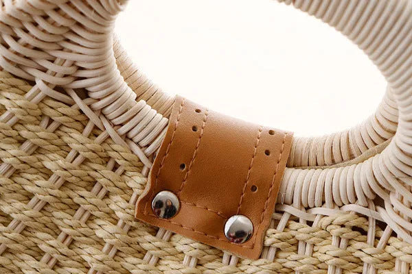 Women's round woven paper rope handbag in beige with hard shell, cover closure, and hard handle