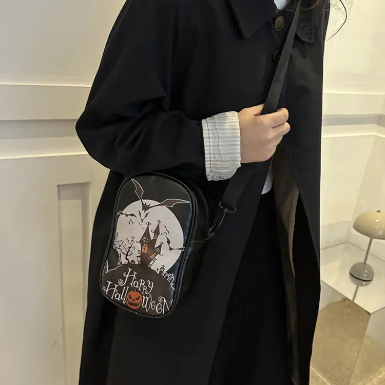 Black mini square crossbody bag with orange Halloween graffiti print of cartoon pumpkin, ghost, and bat.