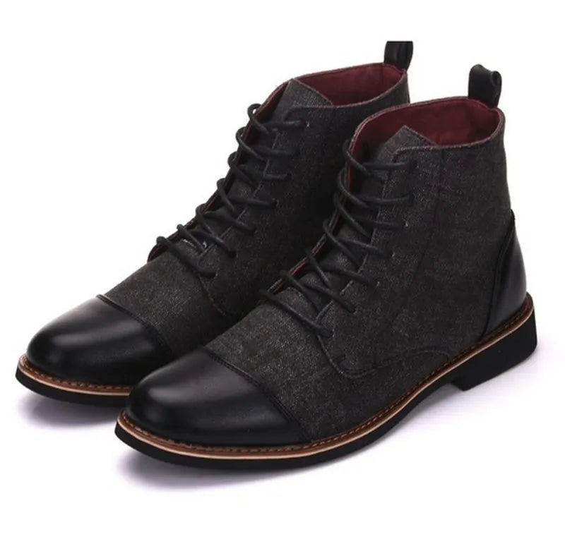 Men's black leather motorcycle ankle boots with side belt buckles and a thick rubber sole on a wooden floor.