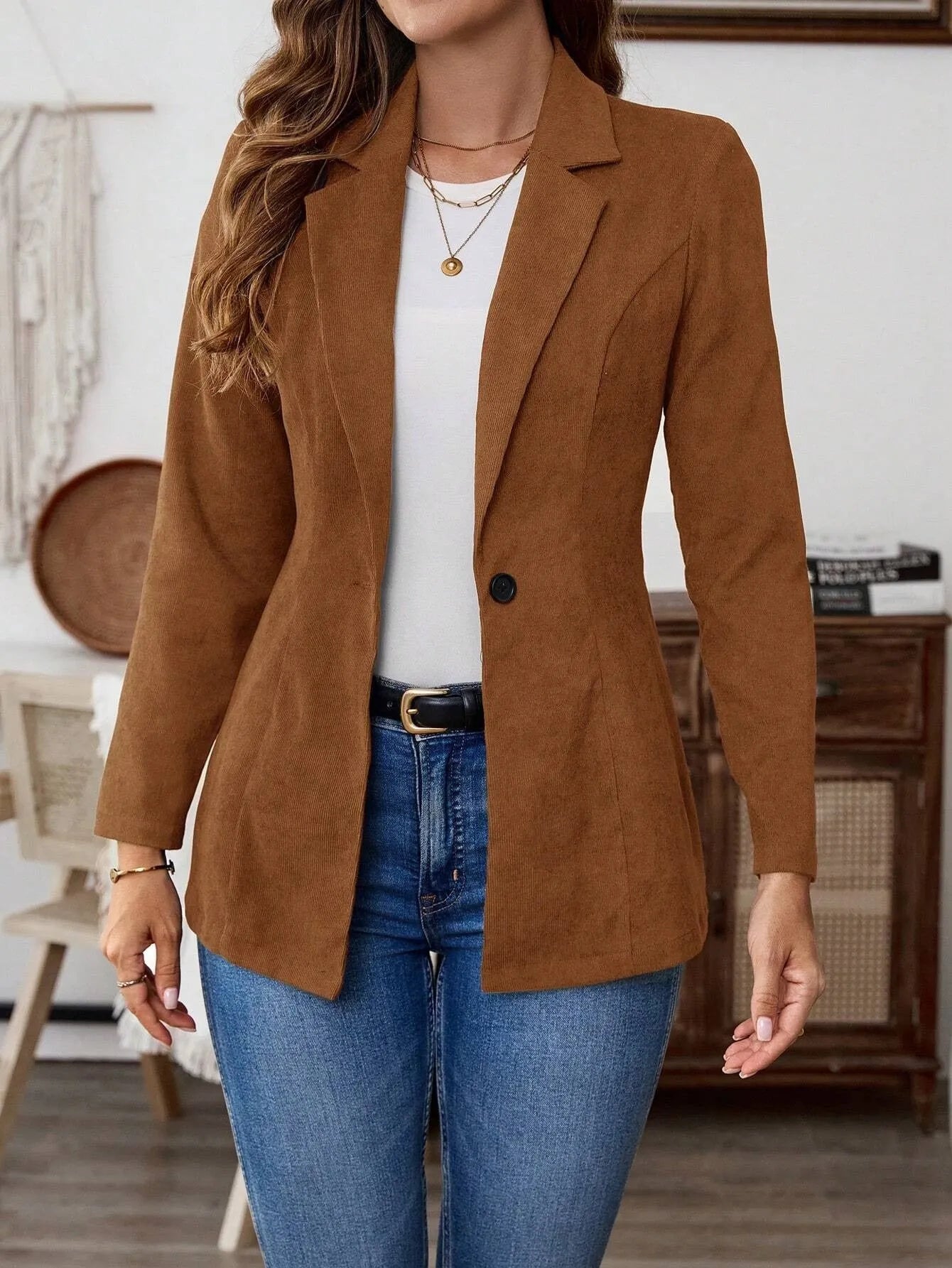 Brown single-breasted suit coat with lapel and long sleeves on a hanger.