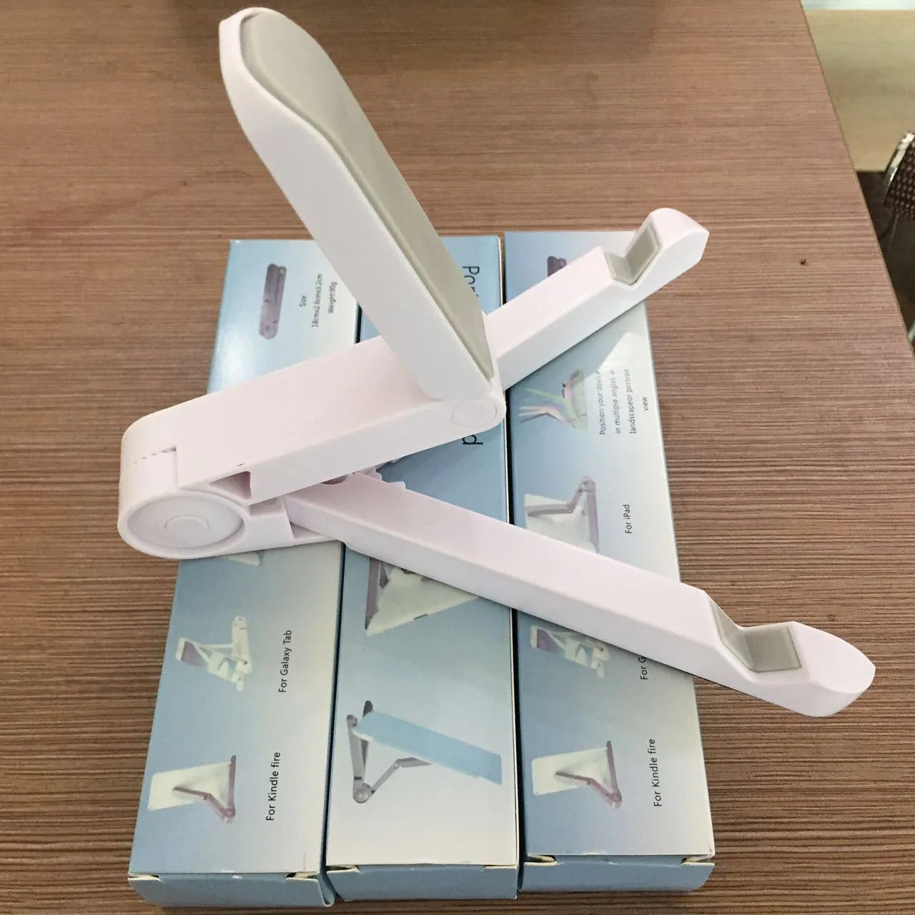 Black foldable tablet holder displaying smartphone in landscape position on desk