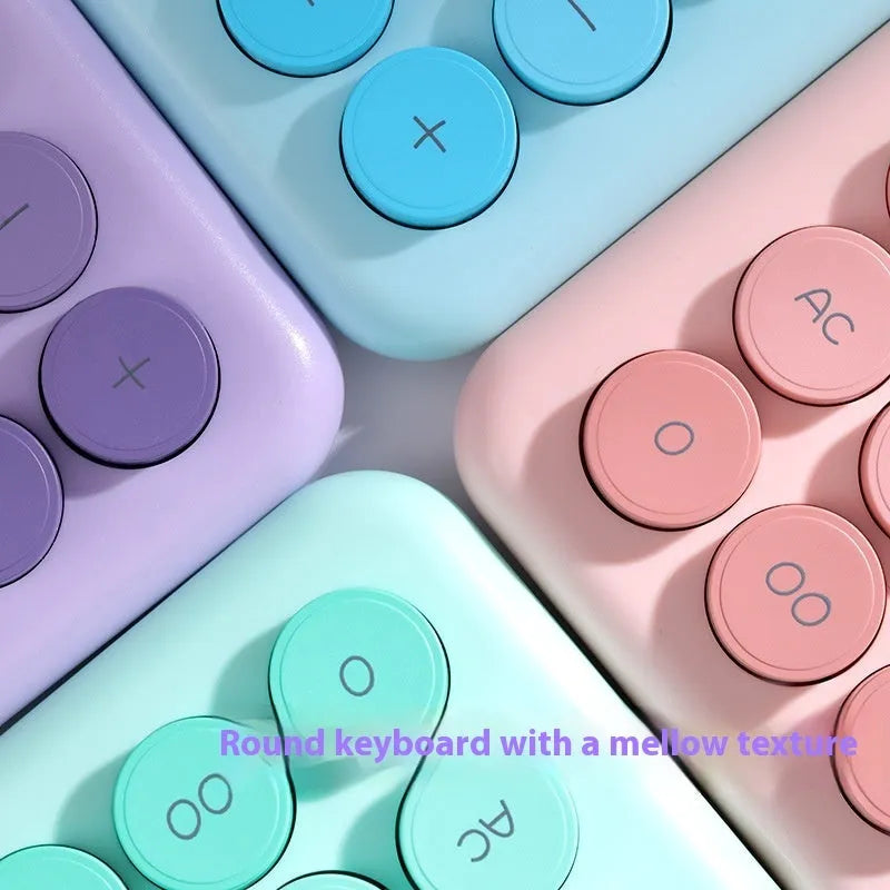 Gradient colour desktop calculator in violet, pink, blue, and green shades on a desk.