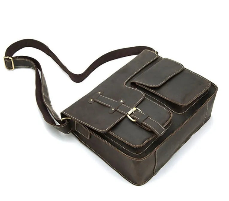 Brown full-grain leather vintage messenger bag with brass hardware, showing front flap and adjustable crossbody strap.