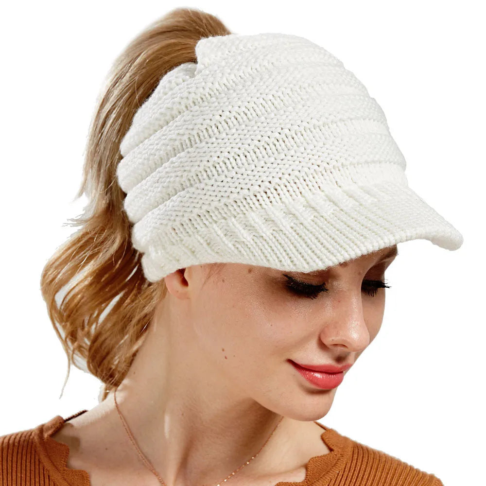 Acrylic knitted ponytail beanie hat for women in a neutral colour, shown on a model with a high ponytail.