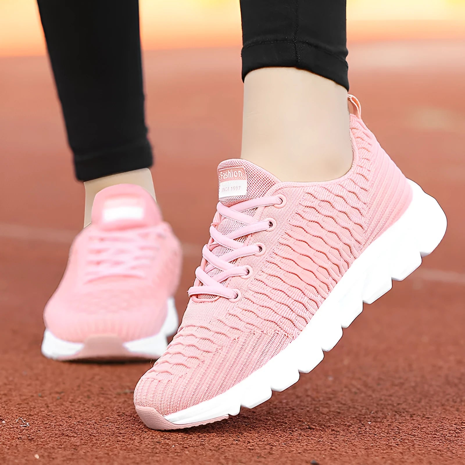 Women's running shoes in black, pink, or white with a mesh upper and rubber outsole.