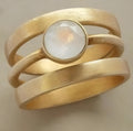 Gold-plated geometric titanium steel ring with a micro-inlaid white chalcedony stone.