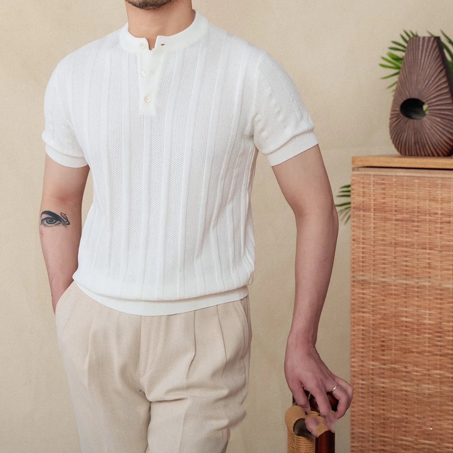 Men's creamy-white knitted short-sleeve t-shirt with a Henry collar and sunken stripe texture.