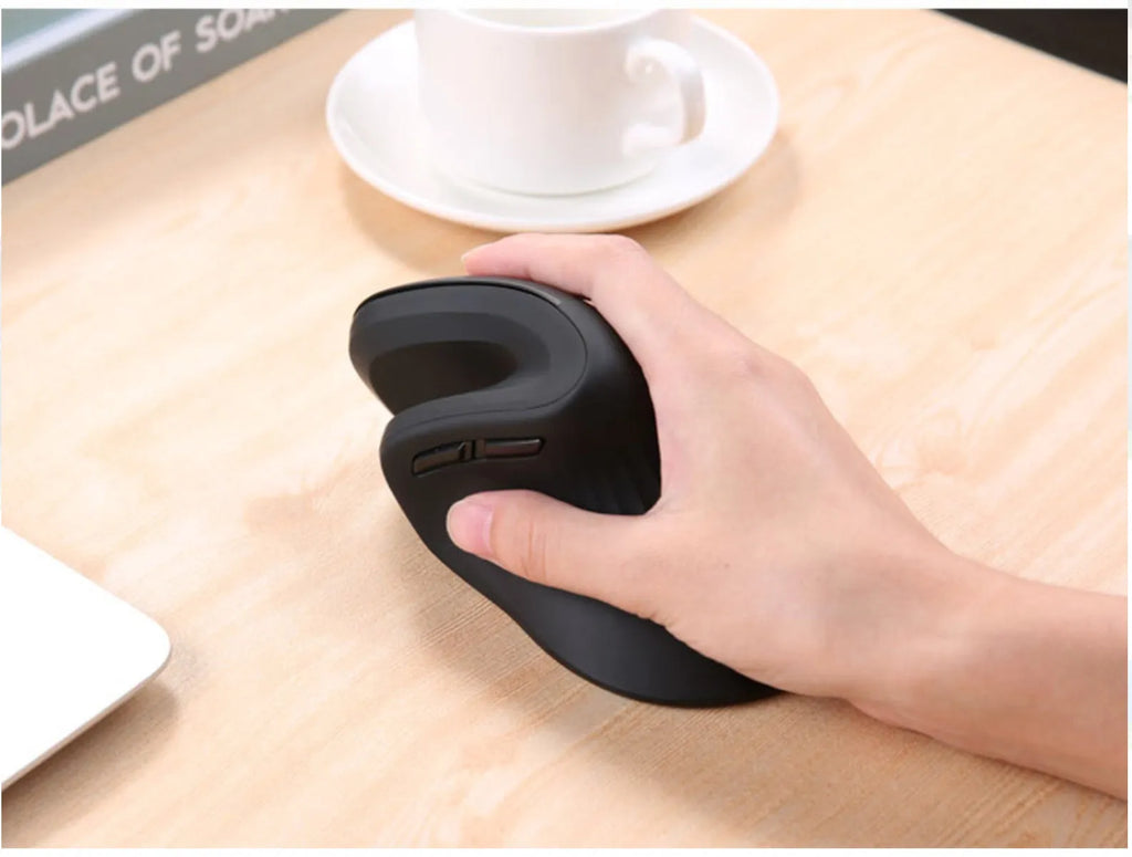 Wireless vertical mouse in black with ergonomic shape, six buttons, and diamond-pattern surface on a desk