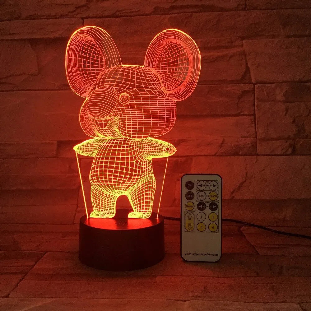 Black koala-shaped LED night light with remote control on a table.
