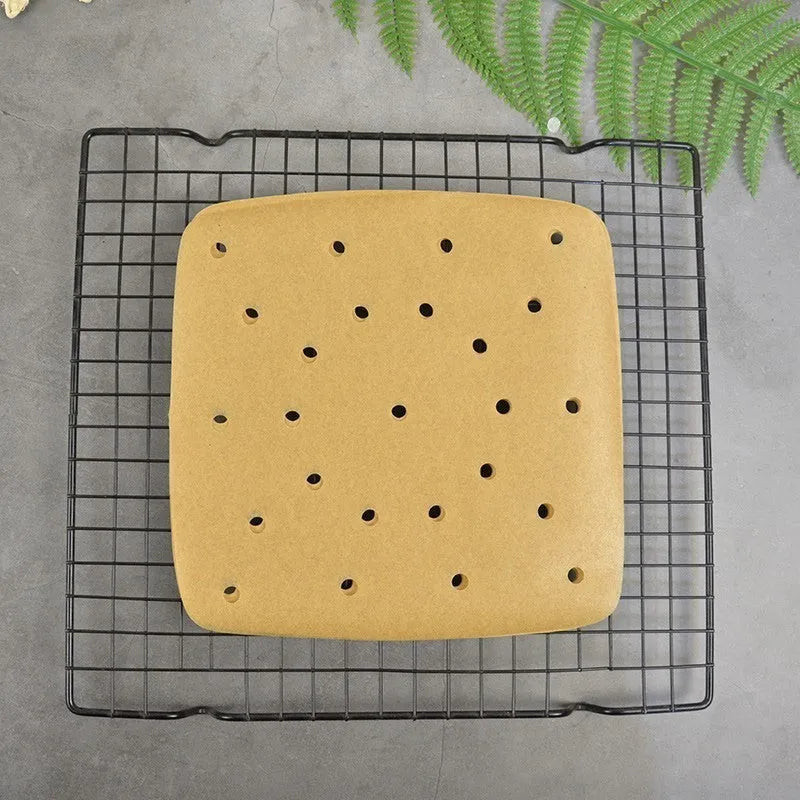 Stack of 200 natural colour oiled baking paper square sheets with holes for air fryer in 20cm and 23cm sizes