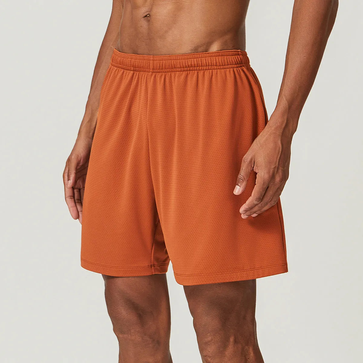 Men's quick-dry double-layer running shorts in a brick red colour on a mid-waist fit model.