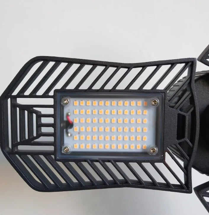 Waterproof foldable industrial garage lamp with die-cast aluminium housing on a workshop bench.