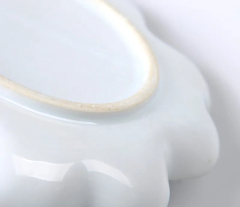 White hand-made ceramic plum blossom shaped artist palette for paint mixing.