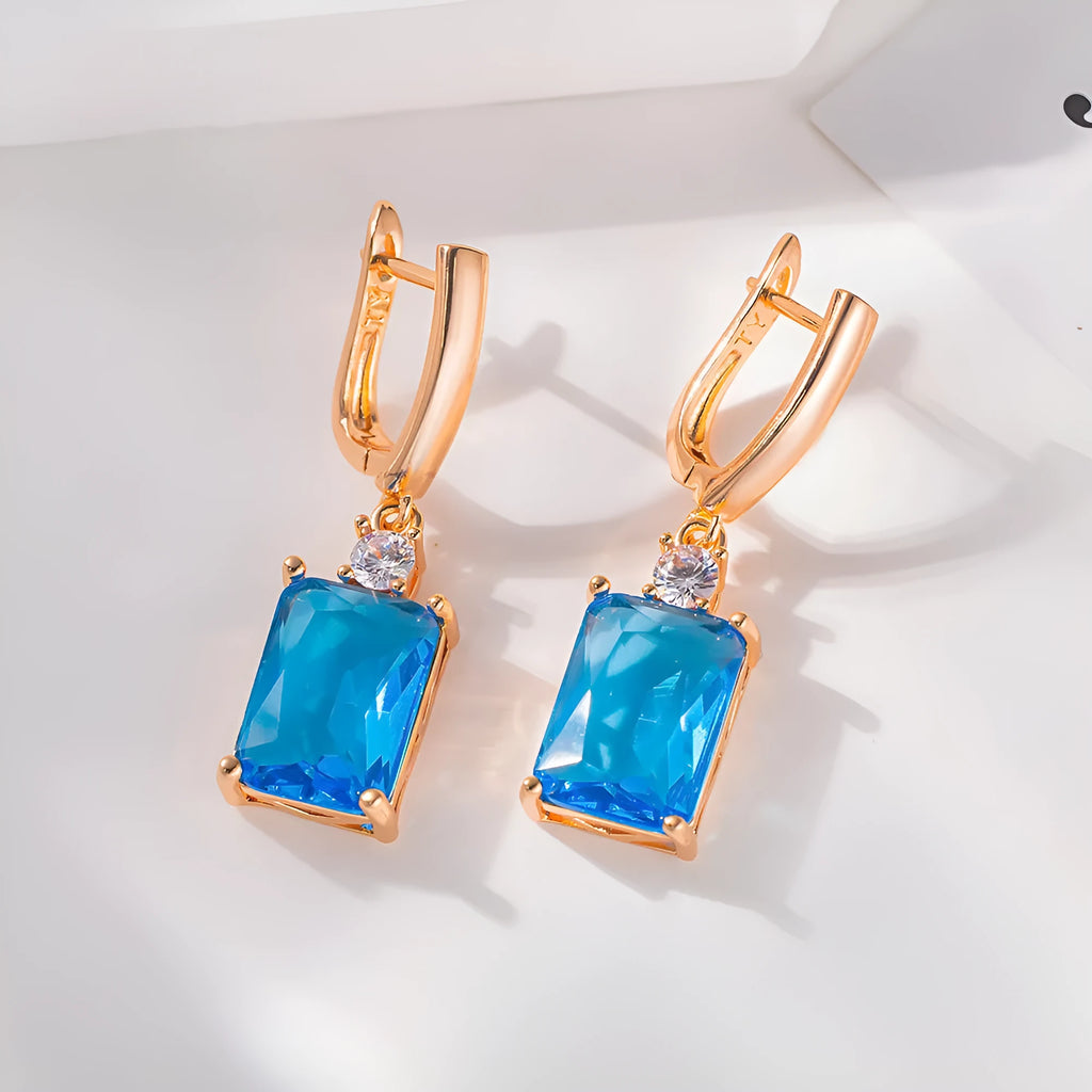 A pair of square gold or silver electroplated copper earrings with geometric design.