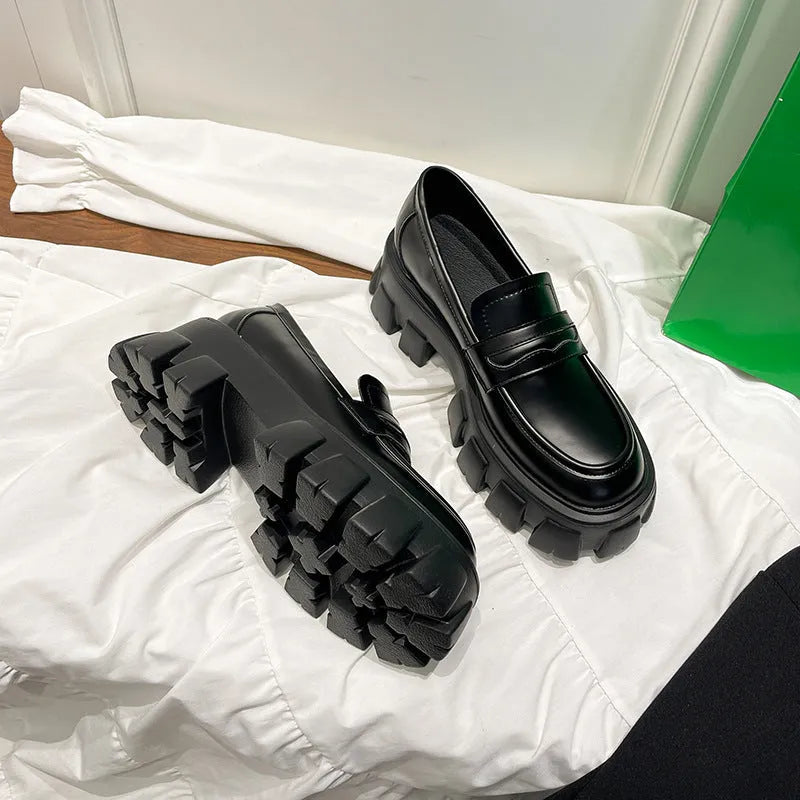 British style wide-fit patent leather loafers with a distinctive muffin heel on a rubber sole.