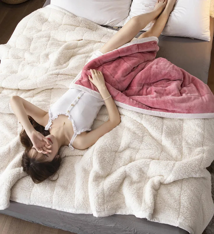 Thick coral fleece winter blanket in a solid colour, shown on a bed, dimensions 150cm by 200cm.