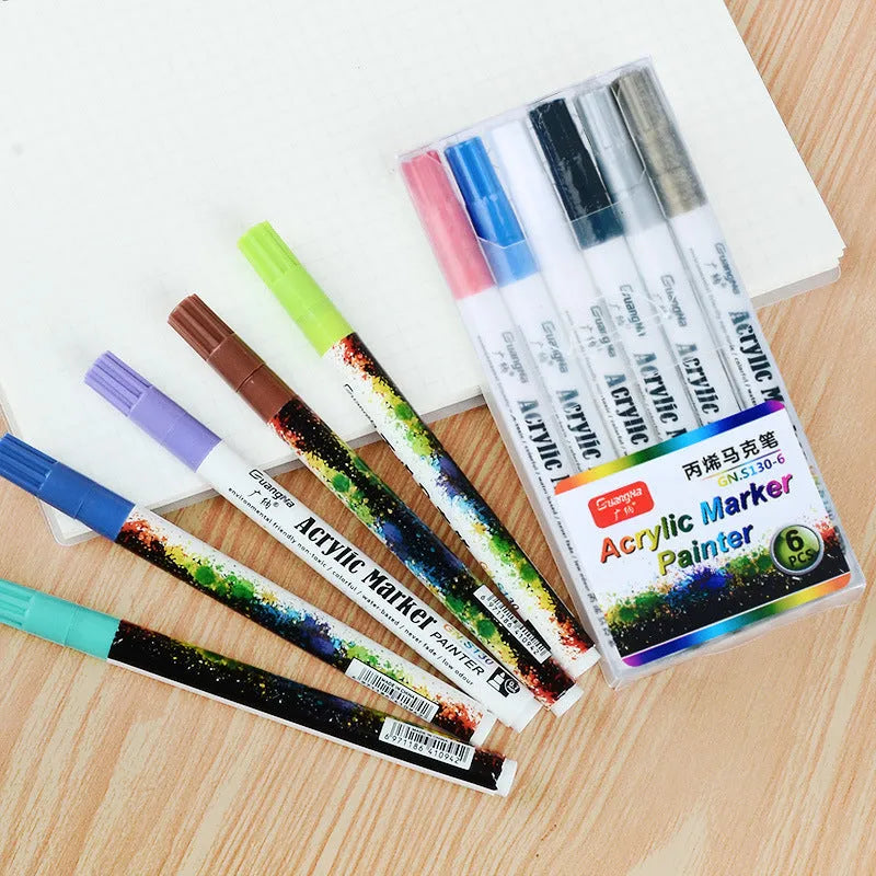 Set of six colourful acrylic graffiti marker pens with 0.7mm tips in a plastic box.