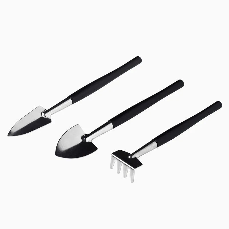 16-piece black mini garden tool set for succulents arranged on a 75cm square cushion mat, includes watering bottles, tweezers, and small shovel.