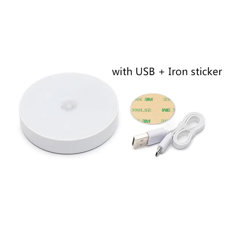 Compact round beige motion sensor LED night light with USB charging cable on a wooden surface