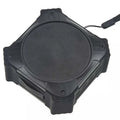 Compact black waterproof Bluetooth speaker with a wrist strap, shown next to a charging cable.