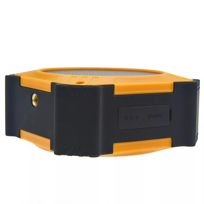 Compact black waterproof Bluetooth speaker with a wrist strap, shown next to a charging cable.