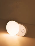 White Baseus rechargeable night light with motion sensor and sleeping light mode on a surface.