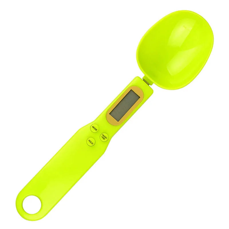 Black electronic digital scale with integrated measuring spoon showing weight display.
