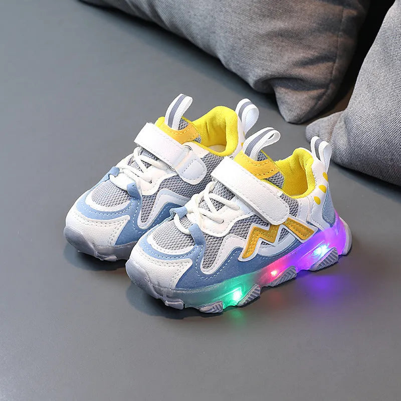 Kids black breathable mesh sneakers with Velcro strap and rubber sole on a grey background.
