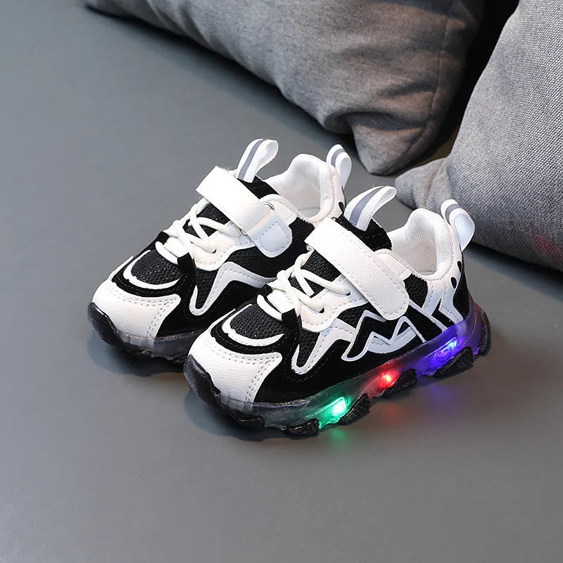 Kids black breathable mesh sneakers with Velcro strap and rubber sole on a grey background.