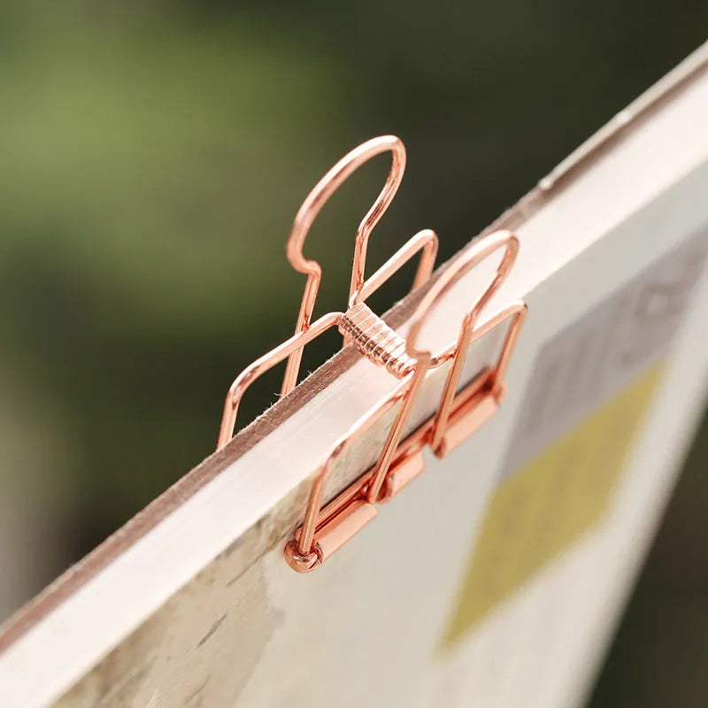 Rose gold metal binder clip set showing eight small and six large clips for document organisation