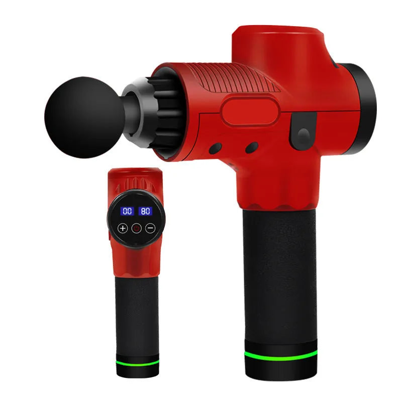 Black electric muscle massage gun with multiple attachment heads on a table.