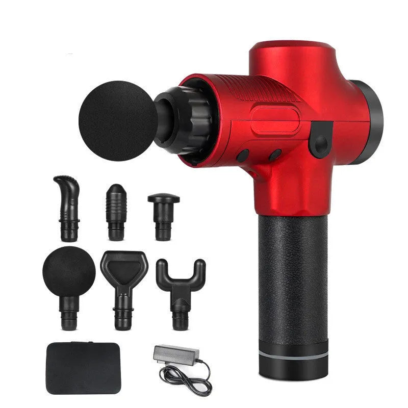 Black electric muscle massage gun with multiple attachment heads on a table.