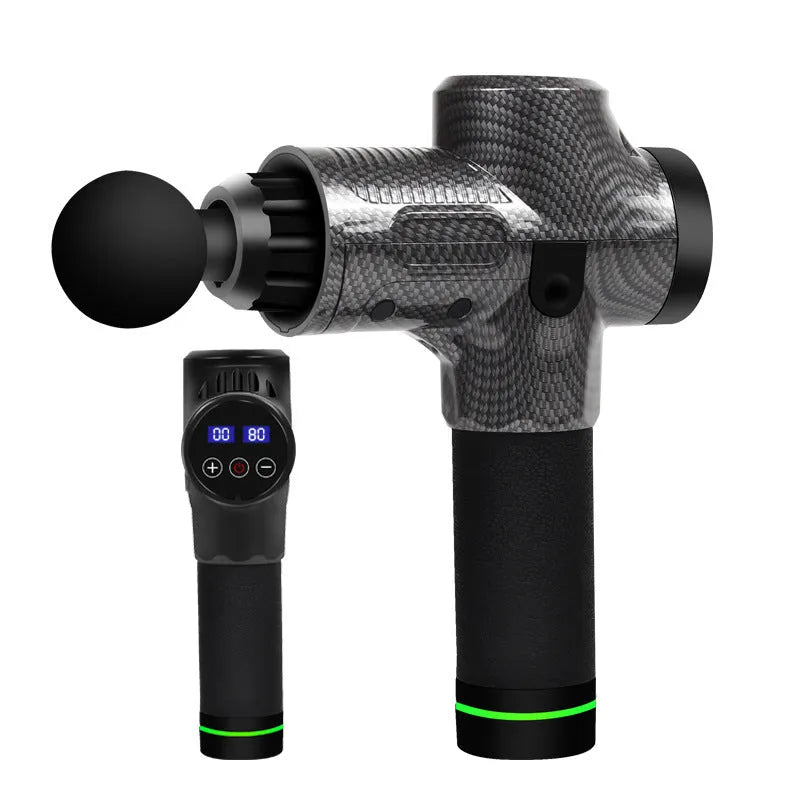 Black electric muscle massage gun with multiple attachment heads on a table.