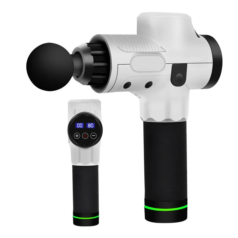 Black electric muscle massage gun with multiple attachment heads on a table.