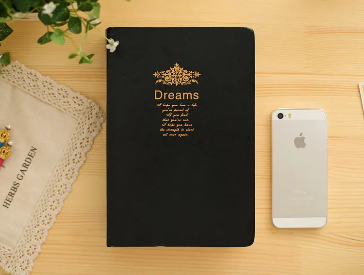 Jingu 25k thick imitation leather notebook open on a desk, showing its 35mm spine and A5 pages.