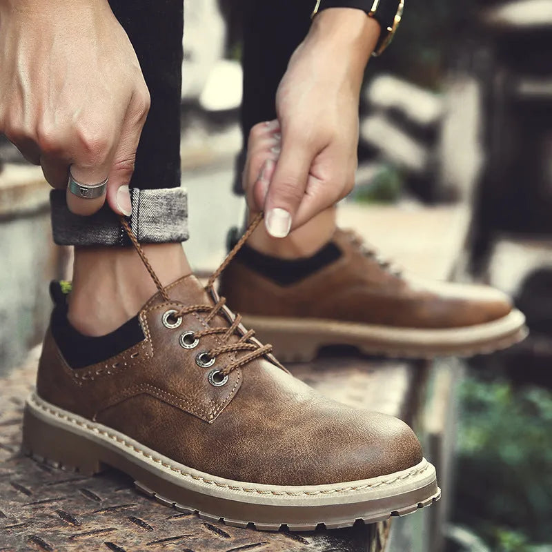 Men's black casual lace-up shoes with a round toe and flat rubber sole on a plain background.