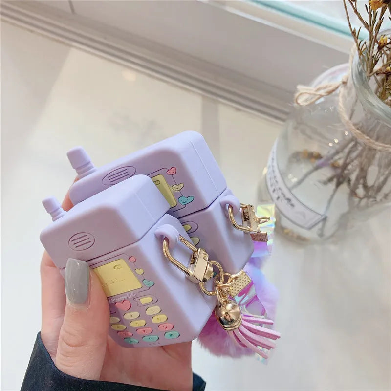 Purple silicone AirPods protective case with fur ball pendant attached to clamshell design