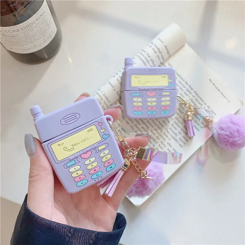 Purple silicone AirPods protective case with fur ball pendant attached to clamshell design